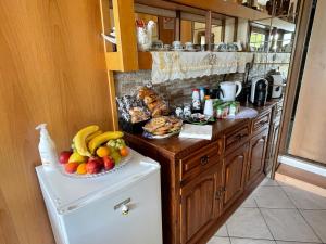 - une cuisine avec une plaque de fruits au-dessus d'un réfrigérateur dans l'établissement Al cervo tra i laghi, à Tavernerio