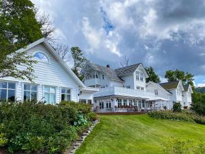 une grande maison blanche avec une cour dans l'établissement Haaheim Gaard, à Uggdal