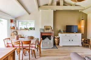 a living room with a table and a fireplace at La Maison des Marais de Sallertaine in Sallertaine