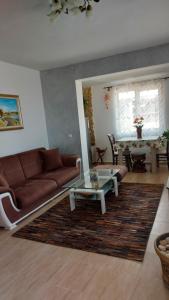 a living room with a brown couch and a table at Акротирия Фешева in Nesebar