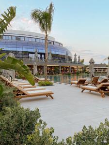 a resort with a pool and lounge chairs and a building at Liu Resorts in Side