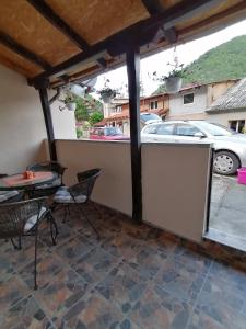 a patio with a table and chairs and a car parked at Apartman Ivona in Ovčar Banja