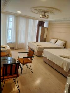 Cette chambre d'hôtel comprend deux lits, une table et des chaises. dans l'établissement Sultanahmet çoşkun hotel, à Istanbul