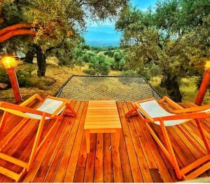 een houten terras met 2 stoelen en een tafel bij Hayal Tadında in Izmir