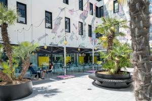 ボローニャにあるThe Social Hub Bolognaのヤシの木が並ぶ中庭