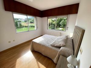 מיטה או מיטות בחדר ב-Grupo Gontad Apartamento As Grelas Canduas 2
