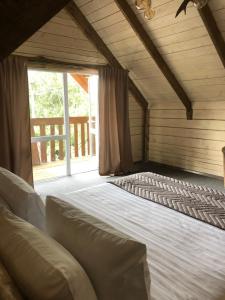 a large bed in a room with a large window at Guest House Three Bears in Belokurikha