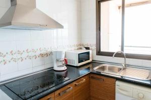 a kitchen with a counter top with a microwave at Playa de Levante Jazmines 16 in Benidorm