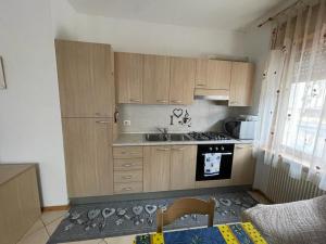 a kitchen with wooden cabinets and a stove top oven at Palazzina Rosa in Spormaggiore