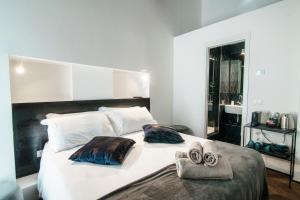sypialnia z dużym białym łóżkiem z ręcznikami w obiekcie Caesar Suites - The House Of Travelers w Como