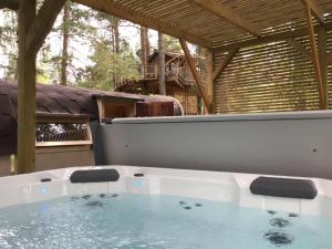 a large bath tub sitting on top of a patio at Treehouse Čiekurs in Duķuri