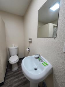 uma casa de banho com um lavatório, um WC e um espelho. em Majestic Inn & Suites em Klamath Falls