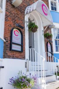 un cartel en la puerta de un edificio con flores en The Roundhouse, en Weymouth