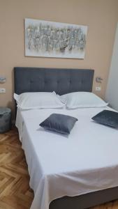 a large white bed with two pillows on it at Apartments Prižmić in Podstrana