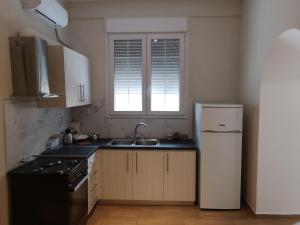 a kitchen with a sink and a refrigerator at Leonidas II Traditional House in Sparta in Sparti +14 photos
