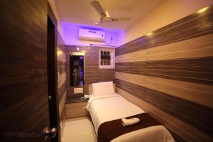 a small room with two beds and a purple light at Vijaya Residency - Porur in Chennai