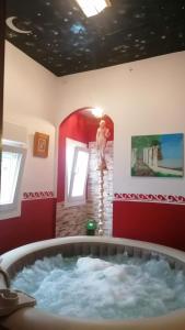 una bañera de hidromasaje en una habitación con un hombre de pie en una escalera en Alojamientos Turísticos Centro de Extremadura en Calamonte