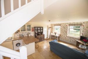 cocina abierta y sala de estar con escalera en Winsbury Cottage, en West Hauxwell