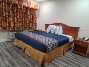 Postel nebo postele na pokoji v ubytování Majestic Inn & Suites