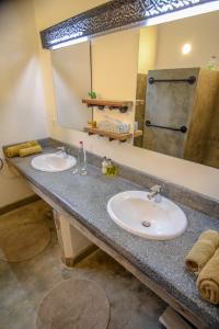 un bagno con due lavandini e un grande specchio di Arusha Villa Karamu Coffee Estate a Usa River