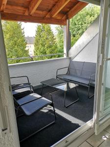 2 Stühle und ein Tisch auf dem Balkon in der Unterkunft Familienfreundliche Ferienwohnung mit Wohlfühlbalkon und kostenlosem Parkplatz nahe Messe und Bodensee in Meckenbeuren