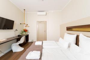 a hotel room with a white bed and white walls at Hotel Casa Colonia in Cologne