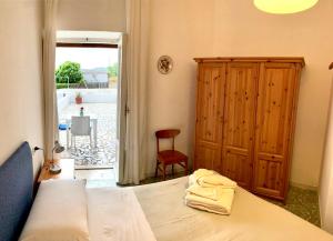 a bedroom with a bed and a cabinet and a window at Villa Egidio in Ischia