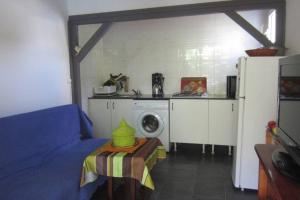 eine Küche mit einem Kühlschrank und einem Tisch im Zimmer in der Unterkunft Le Pavillon in Saint-Louis