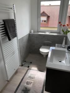 uma casa de banho com um lavatório, um WC e uma janela. em promedklinik apartment 2 em Volkach