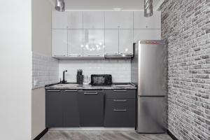 cocina con nevera y pared de ladrillo en Apartments in Arcadia Vip, en Odessa