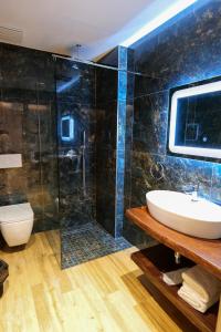 ein Bad mit einem Waschbecken und einer Glasdusche in der Unterkunft Bora Bora Hotel Ksamil in Ksamil