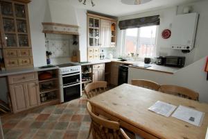 cocina con mesa de madera y comedor en The Pottery Flat Chesterfield Three Star Gold en Chesterfield