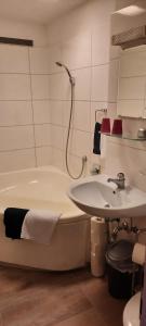 a bathroom with a bath tub and a sink at Wohnen bei den Brückenhäusern in Bad Kreuznach