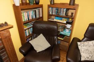 uma cadeira de couro com uma almofada numa sala de estar em The Pottery Flat Chesterfield Three Star Gold em Chesterfield