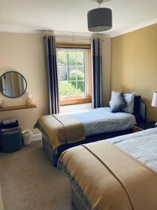 a hotel room with two beds and a mirror at Apartment 101 Kingsmills Road in Inverness