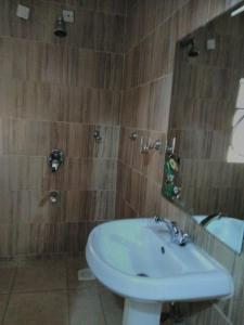 a bathroom with a white sink and a mirror at Nairobi Glory Palace Hotel Ltd in Nairobi