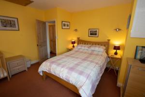 a bedroom with a bed with yellow walls and two lamps at The Pottery Flat Chesterfield Three Star Gold in Chesterfield