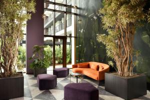 hol biurowy z pomarańczową kanapą i fioletowymi stołkami w obiekcie Milano Verticale | UNA Esperienze w Mediolanie
