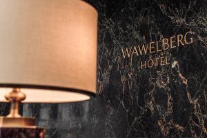 a lamp next to a wall with the words wavereper hotel at Отель Wawelberg in Saint Petersburg