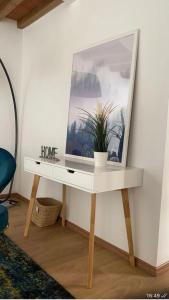 a white table with a mirror and a plant on it at La Torre di Borgunto - Piazza Grande in Arezzo