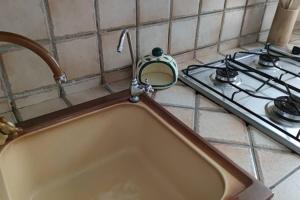 zlew kuchenny z kranem obok kuchenki w obiekcie Appartamento incantevole 90 mq a due passi mare mozzafiato w mieście Isola delle Femmine +17 zdjęć
