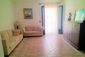 salon z kanapą i krzesłem w obiekcie Appartamento incantevole 90 mq a due passi mare mozzafiato w mieście Isola delle Femmine
