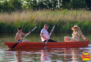 un grupo de personas en un bote rojo en el agua en Kazachiy Khutorok Baza Otdykha, en Kazachiy