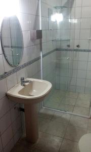 y baño con lavabo y ducha con espejo. en Pousada OceAnas Frente Mar Estaleiro en Balneario Camboriú
