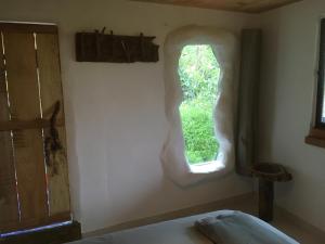 een slaapkamer met een raam in de muur bij Finca Flora del Rio, Habitacion Las Orquideas in Pijao +8 foto's