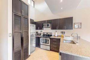 a kitchen with stainless steel appliances and wooden cabinets at The Cove 10 at Playa Ocotal in Coco +19 photos