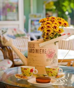un tavolo con due tazze e un vaso con fiori di Hotel Electra a Pomorie