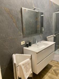 een badkamer met een witte wastafel en een spiegel bij La camera in centro ( 1 minute from Piazza Unita) in Trieste