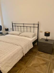 a bedroom with a bed and a nightstand with two lamps at La camera in centro ( 1 minute from Piazza Unita) in Trieste