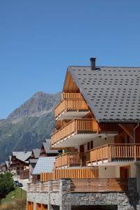 a large wooden building with a slate roof at TERRESENS - LES EDELWEISS in Vaujany